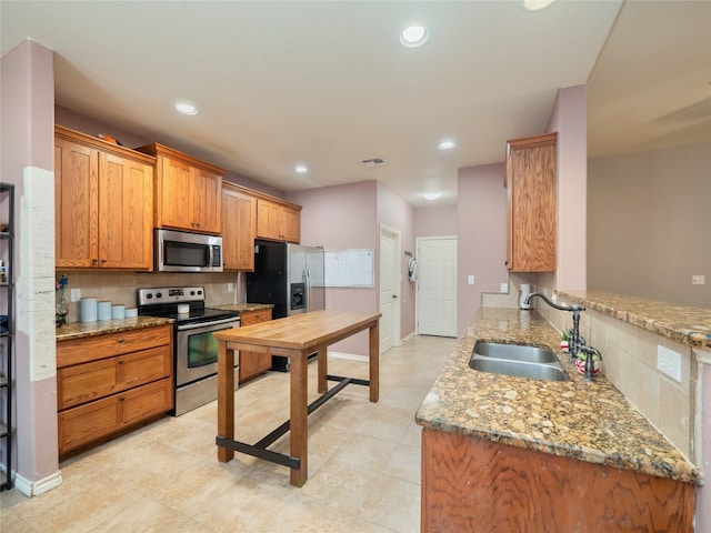 419 Spyglass St, Marble Falls, TX 78654 - kitchen with stainless steel appliances, a sink, decorative backsplash, recessed lighting, and light stone countertops