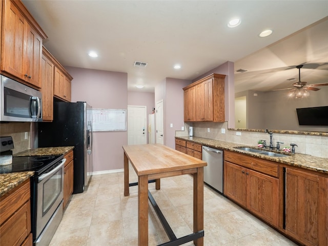 419 Spyglass St, Marble Falls, TX 78654 - kitchen featuring appliances with stainless steel finishes, a sink, brown cabinets, and recessed lighting