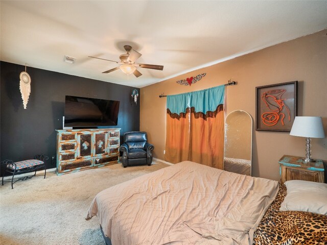 carpeted bedroom featuring baseboards, ceiling fan, and visible vents