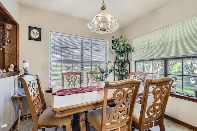 dining space featuring an inviting chandelier, light tile patterned floors, and baseboards
