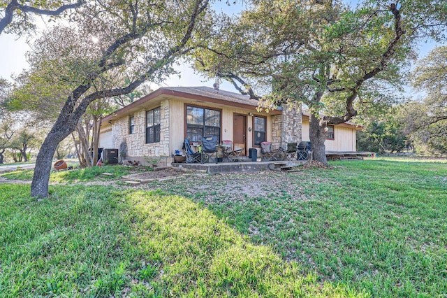view of front of home with central AC and a front yard