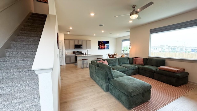 living area featuring ceiling fan, visible vents, stairway, light wood finished floors, and recessed lighting