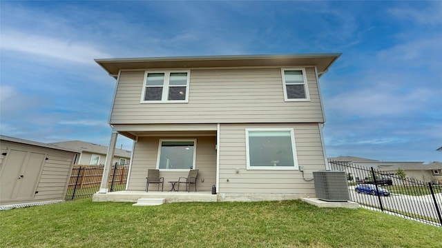 rear view of house featuring central AC, a storage shed, a fenced backyard, an outbuilding, and a patio