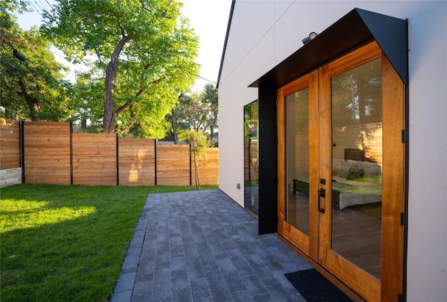 view of yard with a patio, fence, and french doors