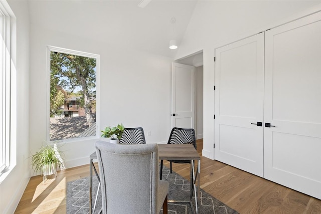 sitting room with baseboards, vaulted ceiling, and light wood-style flooring