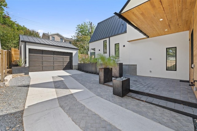 view of side of home with an outdoor structure, stucco siding, metal roof, and a standing seam roof