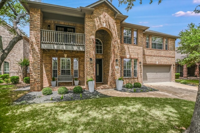 view of front of house featuring a front yard, brick siding, a balcony, concrete driveway, and an attached garage