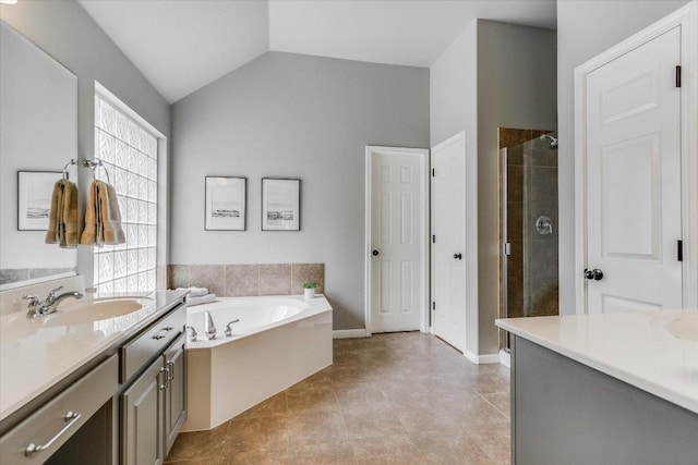 bathroom featuring vanity, a bath, lofted ceiling, and a stall shower