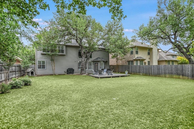 back of property with a lawn, a fenced backyard, and a deck