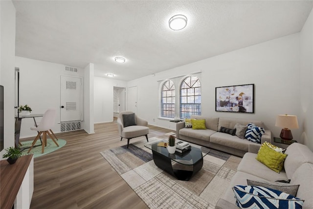 101 E 33rd St Unit 104, Austin, TX 78705 - living area featuring visible vents, baseboards, a textured ceiling, and wood finished floors