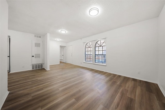 101 E 33rd St Unit 104, Austin, TX 78705 - interior space featuring visible vents, a heating unit, wood finished floors, baseboards, and a textured ceiling