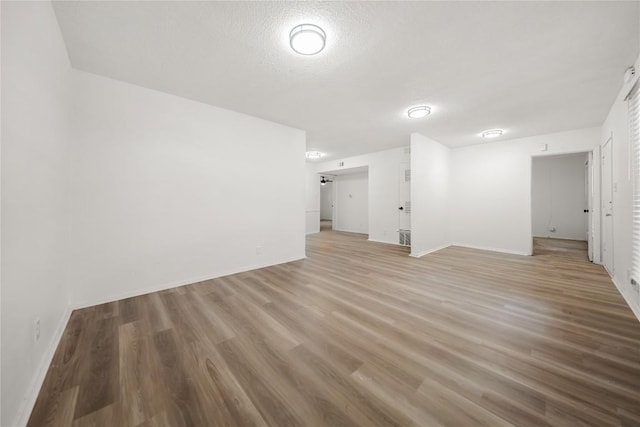 101 E 33rd St Unit 104, Austin, TX 78705 - interior space featuring baseboards, a textured ceiling, and light wood-style flooring