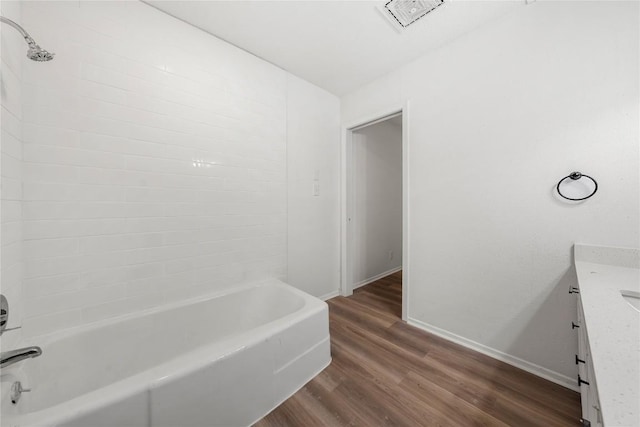 101 E 33rd St Unit 104, Austin, TX 78705 - full bath featuring visible vents, vanity, wood finished floors, baseboards, and washtub / shower combination