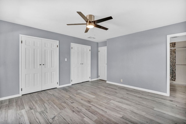 721 Fawn, Horseshoe Bay, TX 78657 - unfurnished bedroom featuring two closets, wood finished floors, and ceiling fan