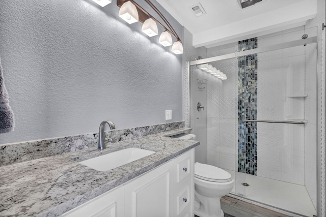 721 Fawn, Horseshoe Bay, TX 78657 - bathroom with a textured wall, wood finished floors, a shower stall, and vanity