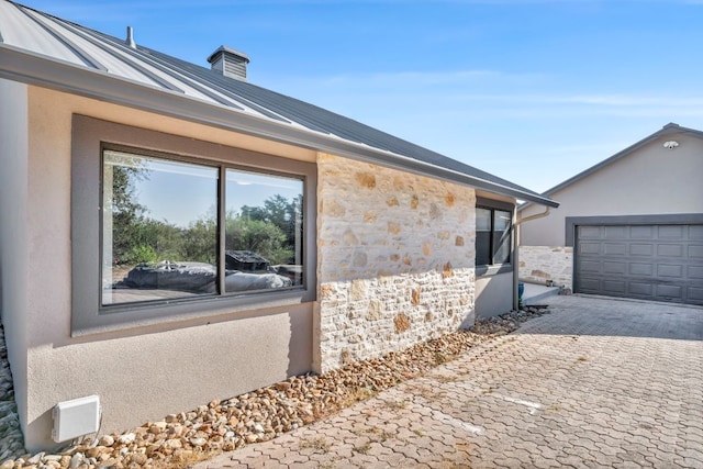 721 Fawn, Horseshoe Bay, TX 78657 - view of side of property with stone siding, stucco siding, a garage, a chimney, and decorative driveway