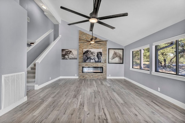 721 Fawn, Horseshoe Bay, TX 78657 - unfurnished living room featuring a ceiling fan, wood finished floors, a large fireplace, and stairway