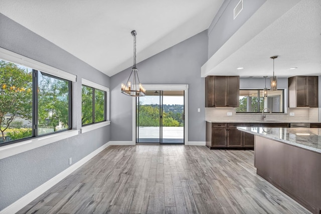 721 Fawn, Horseshoe Bay, TX 78657 - kitchen with a chandelier, healthy amount of natural light, light wood-type flooring, and lofted ceiling