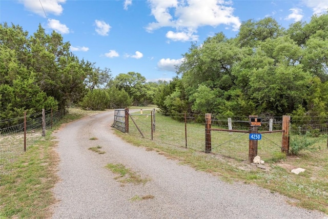 view of road featuring a gate and a forest view