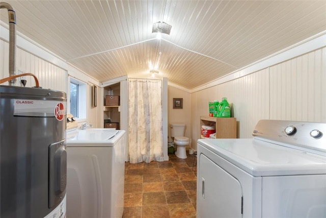 laundry room with a sink, washer and dryer, stone finish floor, and electric water heater