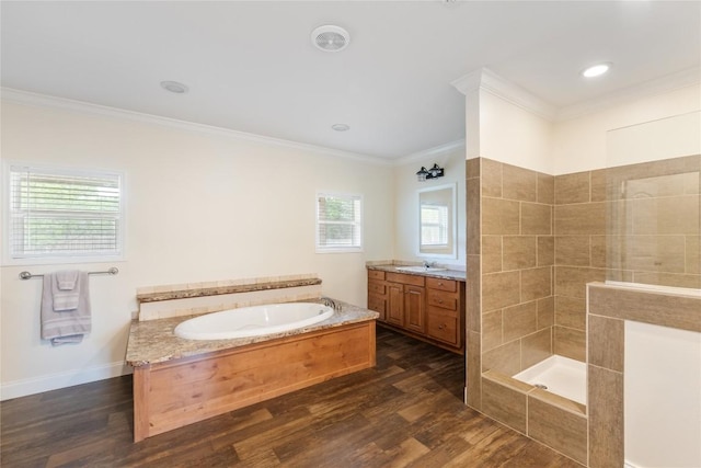 full bathroom featuring a bath, ornamental molding, vanity, and wood finished floors