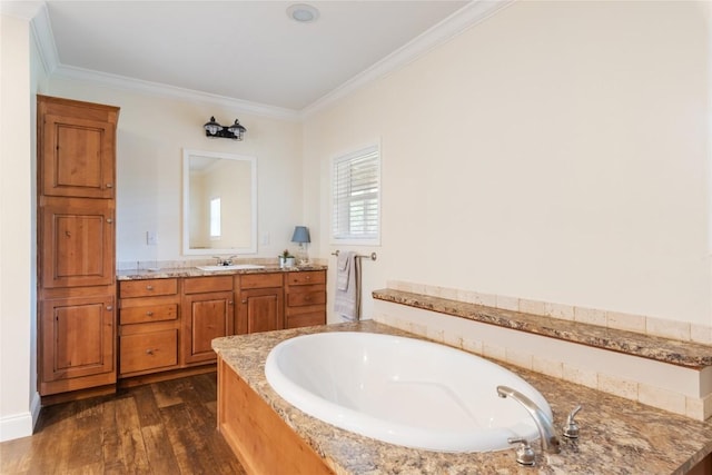 full bathroom featuring crown molding, a garden tub, wood finished floors, and vanity