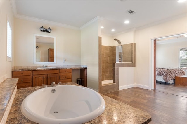 full bathroom featuring visible vents, crown molding, wood finished floors, a walk in shower, and ensuite bath