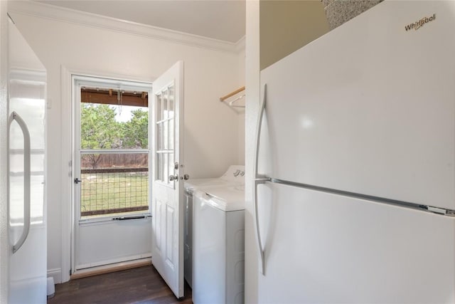 clothes washing area featuring crown molding, laundry area, washing machine and dryer, and dark wood-style flooring