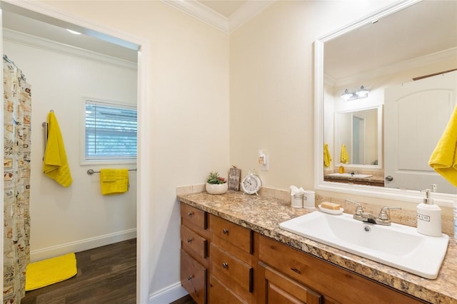 bathroom featuring crown molding, baseboards, wood finished floors, and vanity