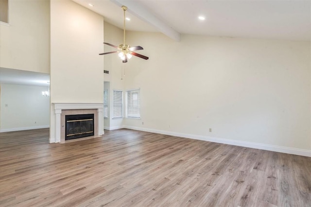 unfurnished living room featuring a tiled fireplace, baseboards, ceiling fan, and light wood-type flooring