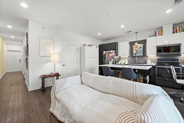 living room featuring visible vents, recessed lighting, dark wood-style flooring, and baseboards
