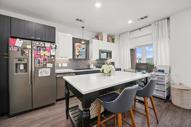 4361 S Congress Ave Unit 427, Austin, TX 78745 - kitchen with stainless steel appliances, a sink, light countertops, a breakfast bar area, and wood finished floors