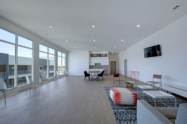 living area with recessed lighting, baseboards, visible vents, and wood finished floors