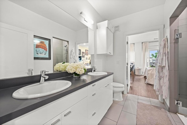 4361 S Congress Ave Unit 427, Austin, TX 78745 - bathroom featuring double vanity, a shower stall, tile patterned floors, toilet, and ensuite bath