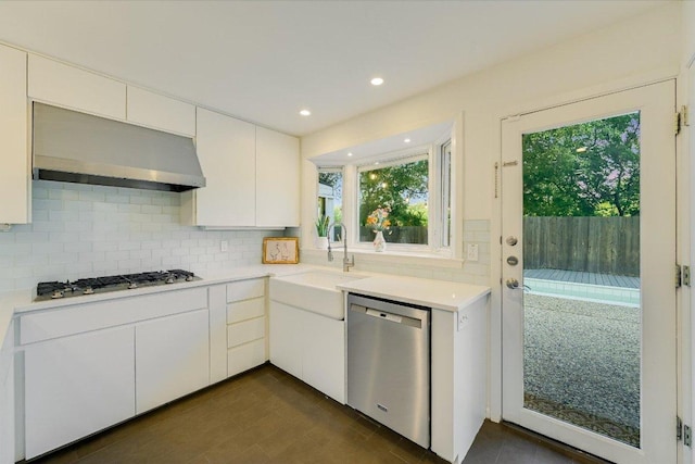 3514 Lakeland Dr, Austin, TX 78731 - kitchen featuring appliances with stainless steel finishes, wall chimney range hood, light countertops, backsplash, and white cabinets