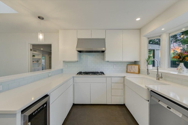 3514 Lakeland Dr, Austin, TX 78731 - kitchen with extractor fan, stainless steel appliances, wine cooler, backsplash, and light countertops