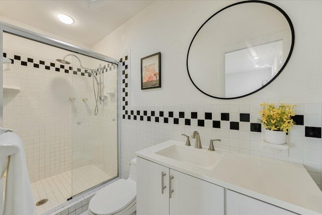 3514 Lakeland Dr, Austin, TX 78731 - bathroom featuring a shower stall, tile walls, vanity, and toilet