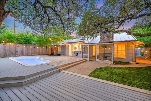 3514 Lakeland Dr, Austin, TX 78731 - pool at dusk featuring a lawn, a deck, a fenced in pool, and a fenced backyard