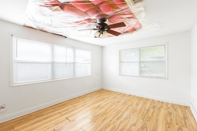 spare room featuring baseboards, ceiling fan, and wood finished floors