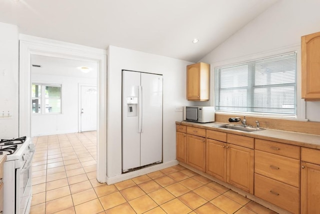 kitchen with light tile patterned flooring, white appliances, light countertops, a sink, and vaulted ceiling