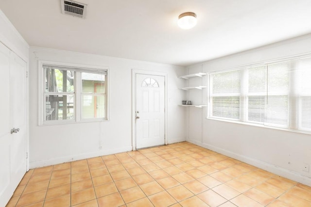 empty room with crown molding and visible vents