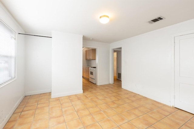 spare room featuring baseboards, visible vents, and ornamental molding