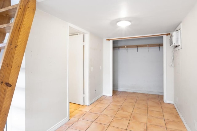 corridor with light tile patterned floors, baseboards, and a wall mounted AC