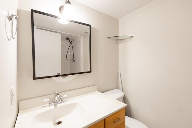 full bath featuring vanity, a shower, and toilet