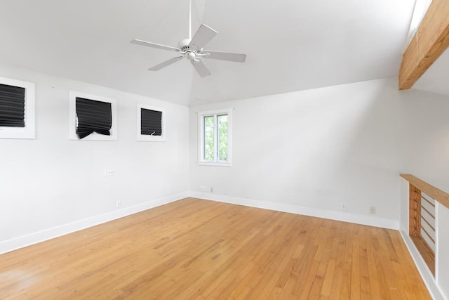 unfurnished room with light wood-style floors, baseboards, ceiling fan, and lofted ceiling with beams