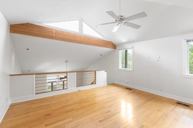 bonus room featuring a healthy amount of sunlight, vaulted ceiling with beams, ceiling fan, and light wood-style floors