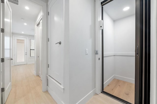 hall featuring recessed lighting, baseboards, visible vents, and elevator