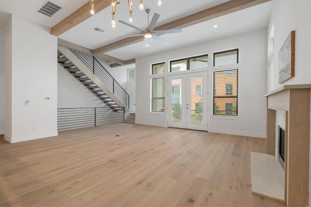 13312 Galleria Cir, Austin, TX 78738 - unfurnished living room with beamed ceiling, healthy amount of natural light, light wood finished floors, a ceiling fan, and a premium fireplace