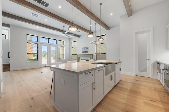 13312 Galleria Cir, Austin, TX 78738 - kitchen featuring french doors, open floor plan, a sink, ceiling fan, and light wood-type flooring
