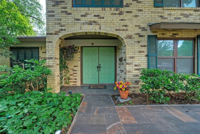 doorway to property featuring brick siding